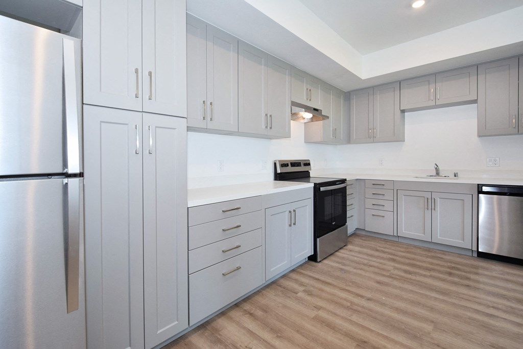 a kitchen with white cabinets and a wood floor