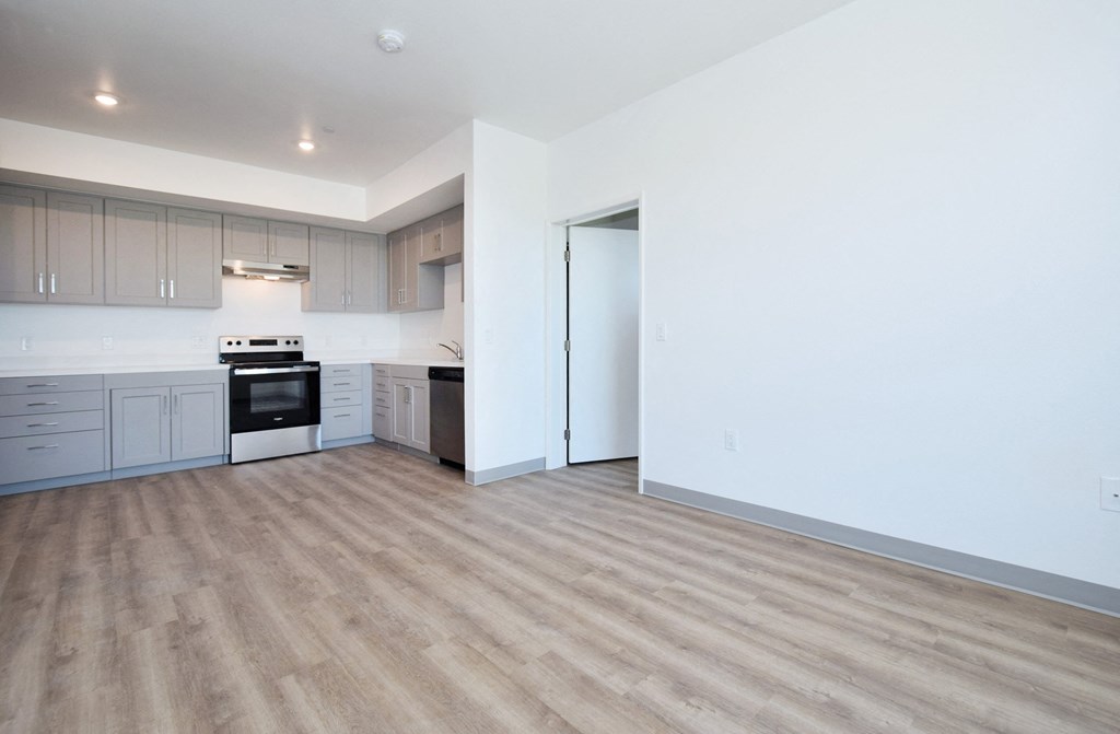 a kitchen with white walls and a wooden floor