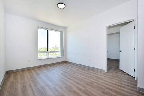 an empty living room with white walls and a window