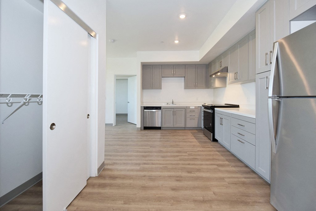 a kitchen with white cabinets and a wooden floor