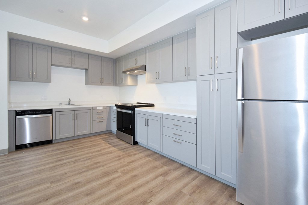 a kitchen with white cabinets and a wooden floor
