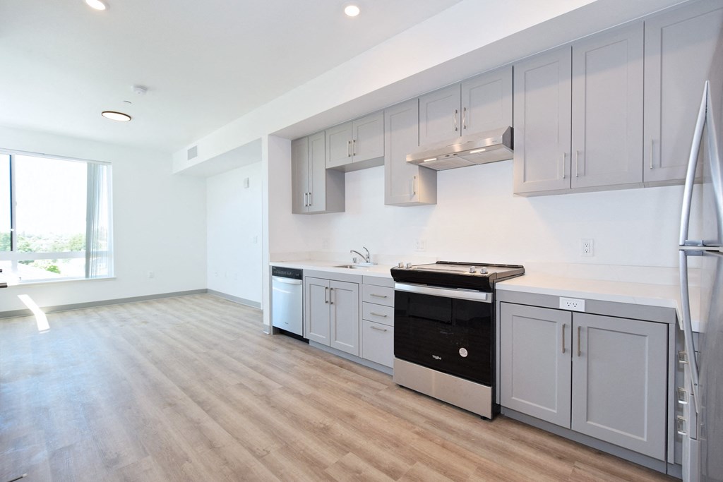 a kitchen with white cabinets and a black stove top oven
