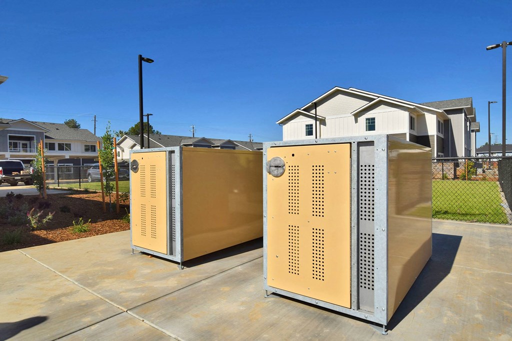 a pair of refrigerators sit on a driveway in front of a row of houses
