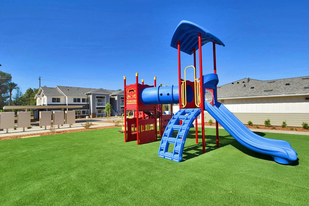 a playground with a blue and red slide and red monkey bars