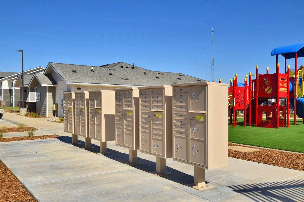 a row of mailboxes sit in front of a playground