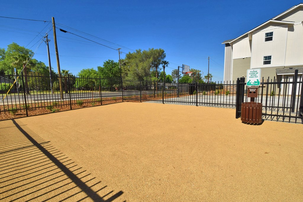 a large fenced in yard with trees in the background