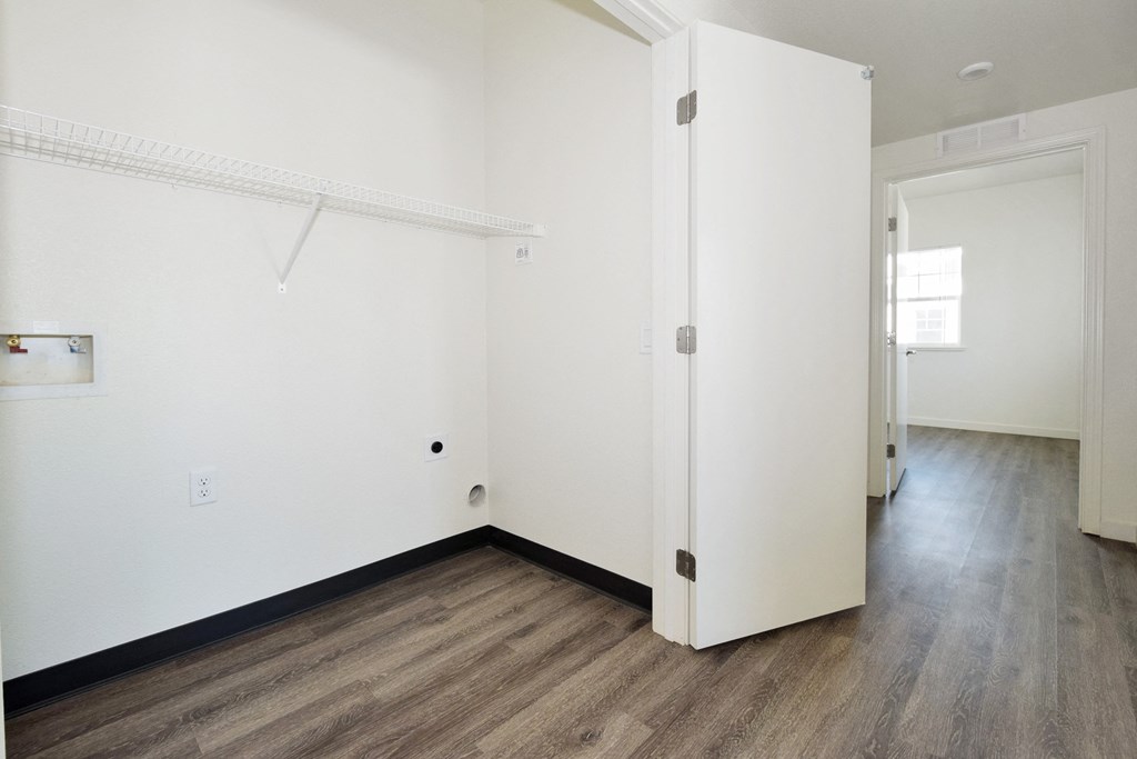 a bedroom with white walls and hardwood floors