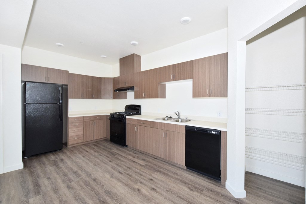 a kitchen with wooden cabinets and a black refrigerator