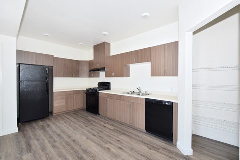 a kitchen with wooden cabinets and a black refrigerator