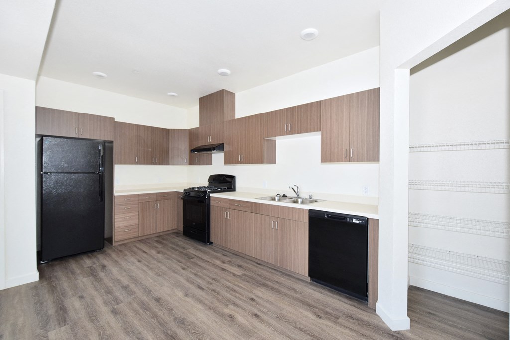 a kitchen with wooden cabinets and a black refrigerator