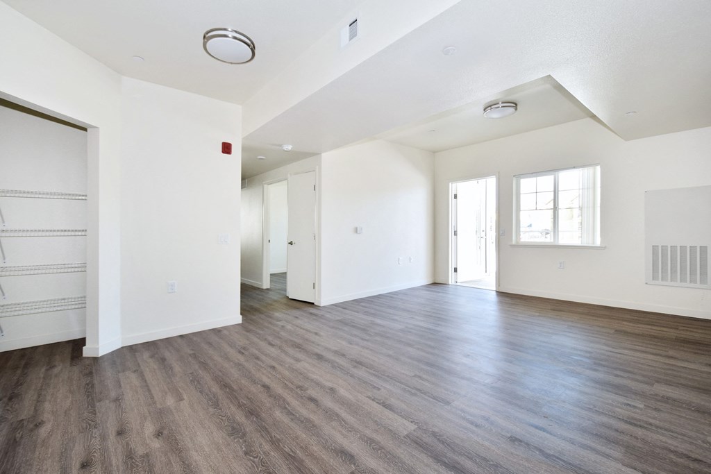 an empty living room with white walls and wood floors