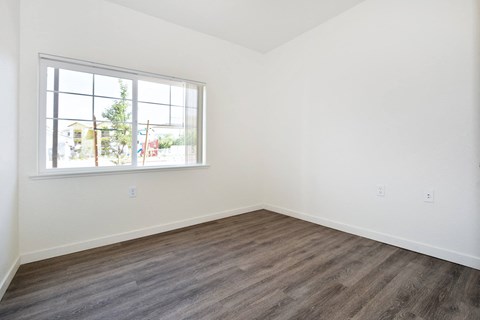 an empty room with white walls and a window