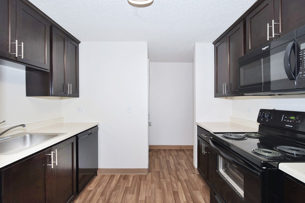 a kitchen with black cabinets and a black stove top oven