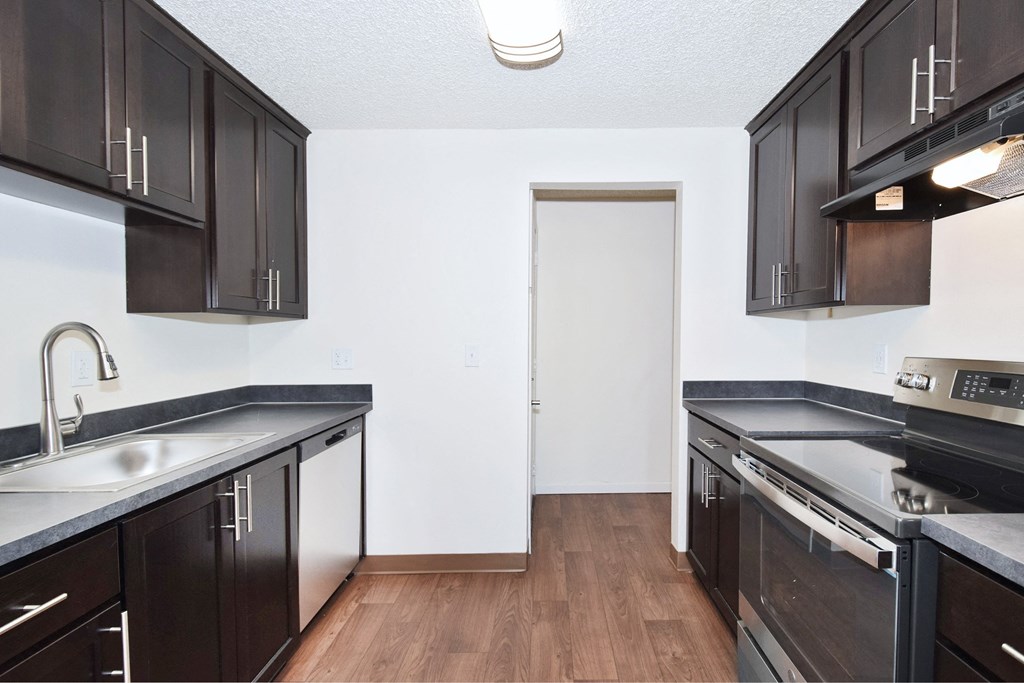 a kitchen with black cabinets and white countertops