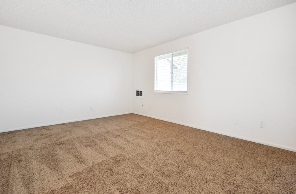 a bedroom with white walls and a window
