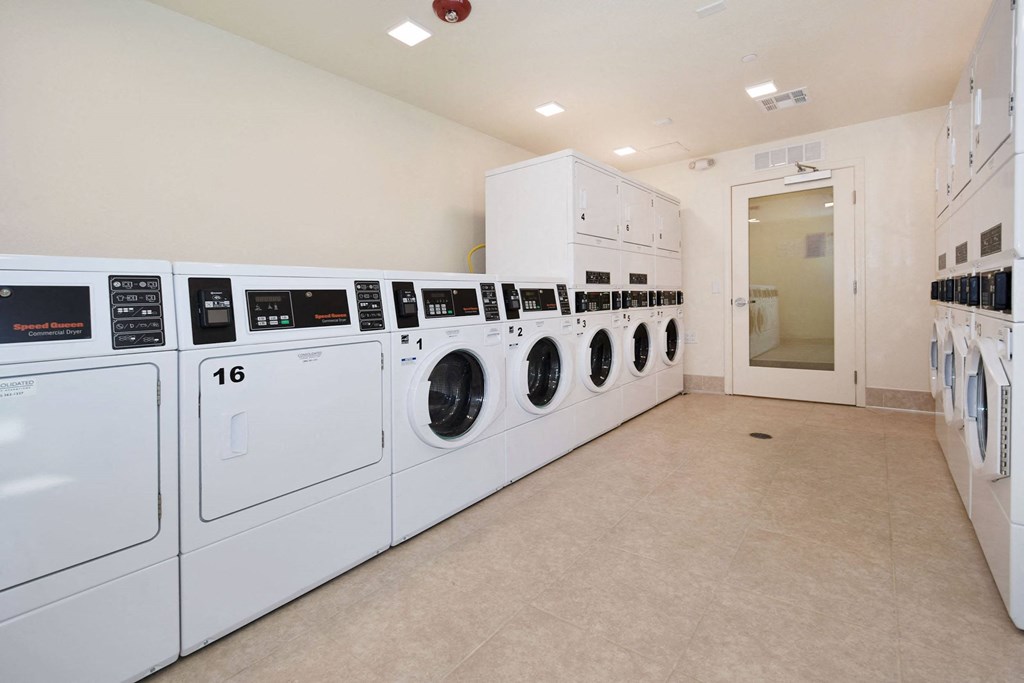 a laundry room with white washers and dryers