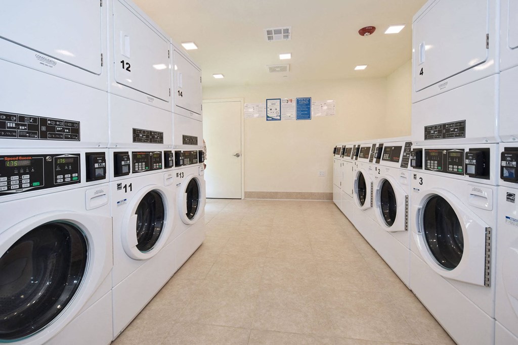 a laundry room with white washers and dryers