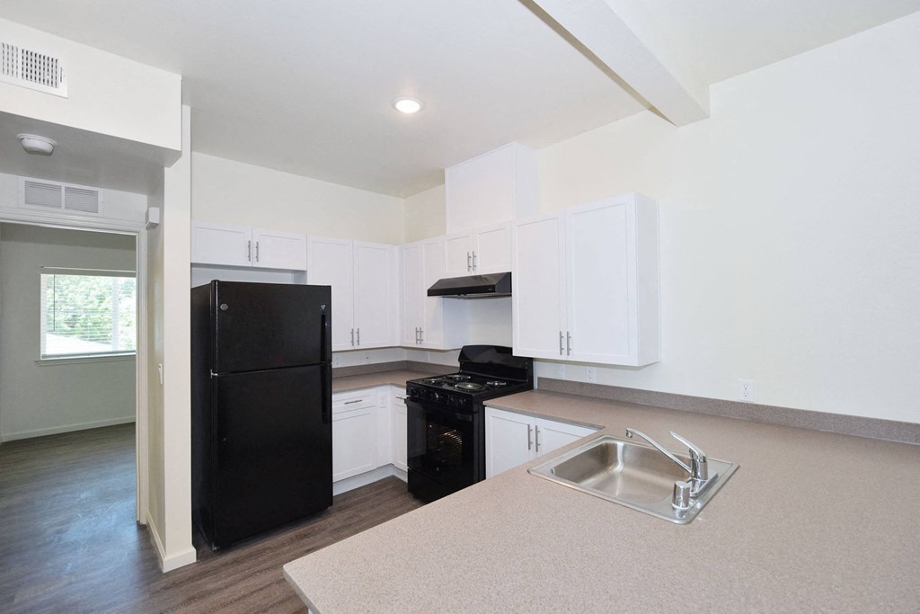a kitchen with white cabinets and black appliances