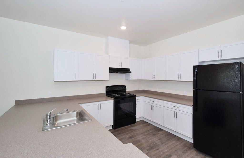 a kitchen with white cabinets and black appliances