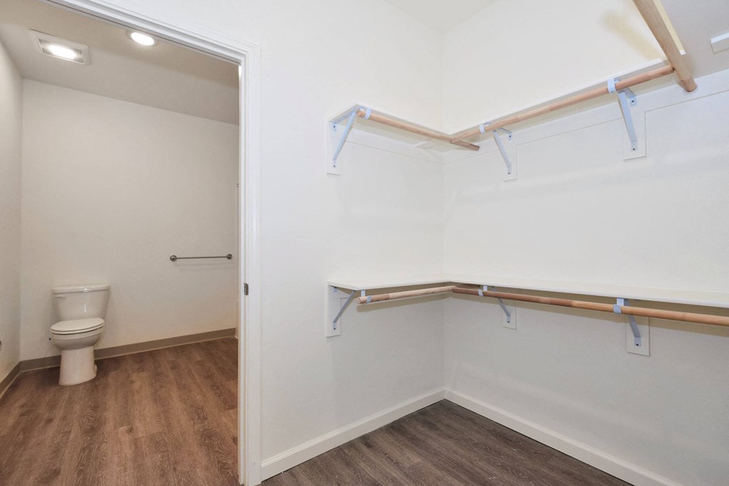 a bathroom with white walls and wood flooring