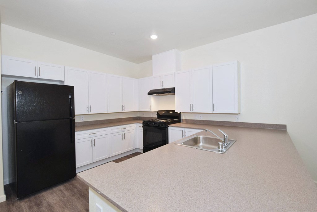 a kitchen with white cabinets and black appliances