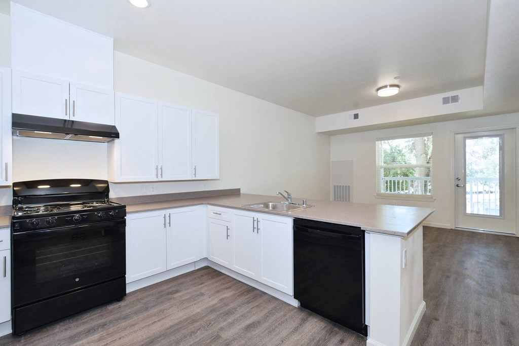 a kitchen with white cabinets and black appliances