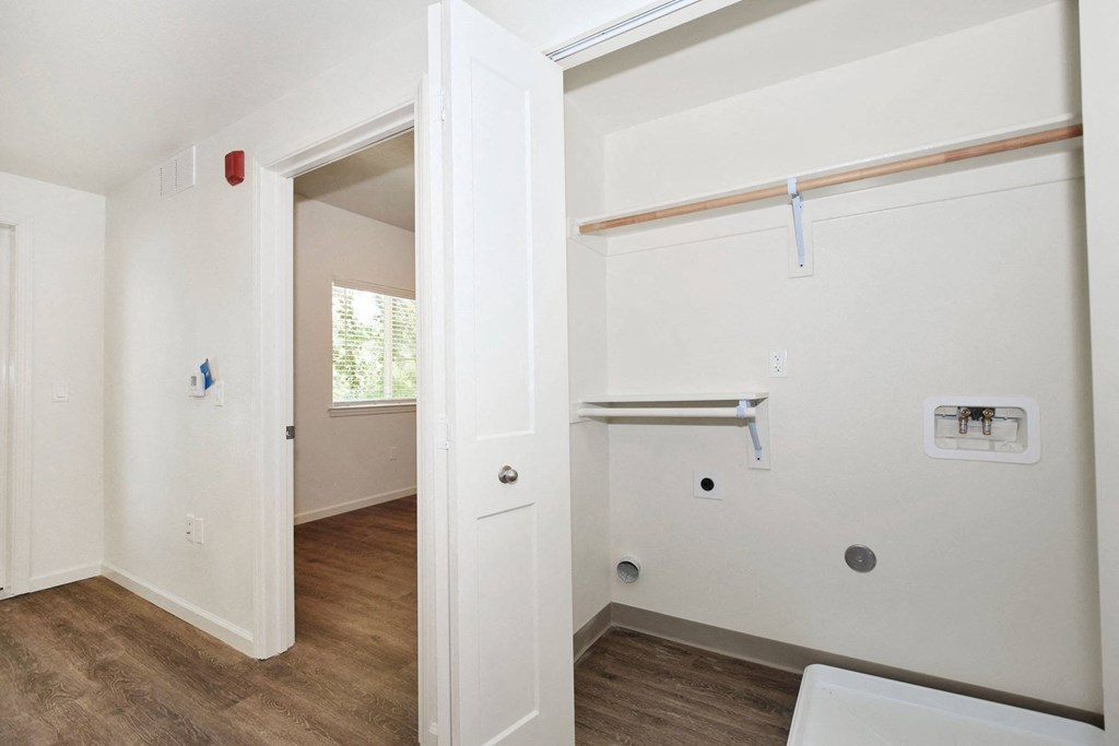 a bedroom with white walls and hardwood floors