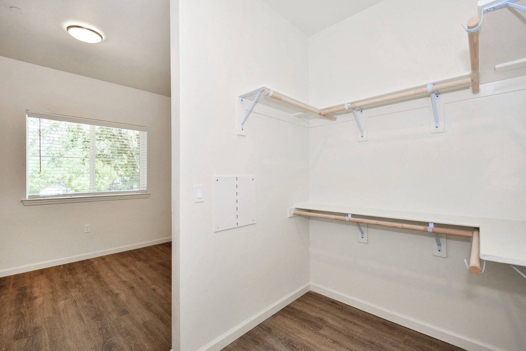 a bedroom with white walls and a window