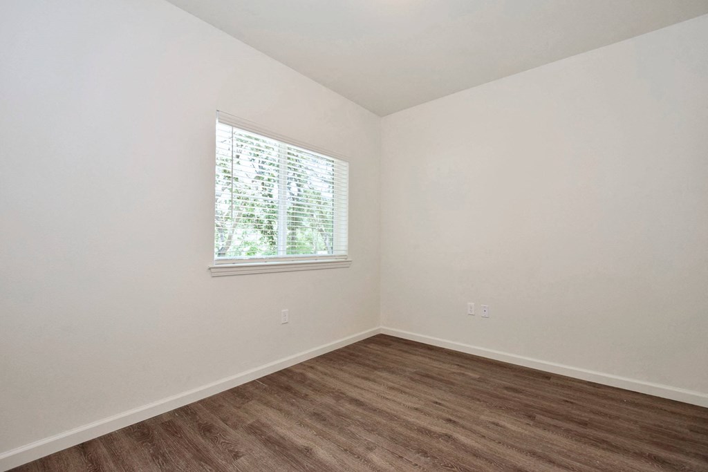 a bedroom with white walls and a window