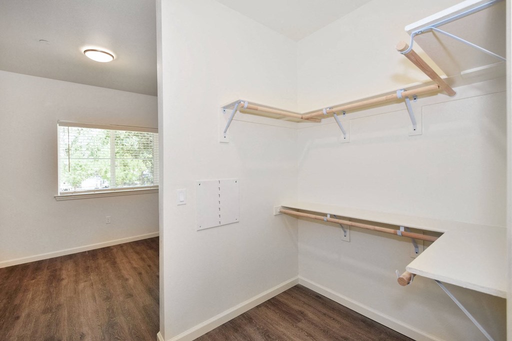a bedroom with white walls and a window