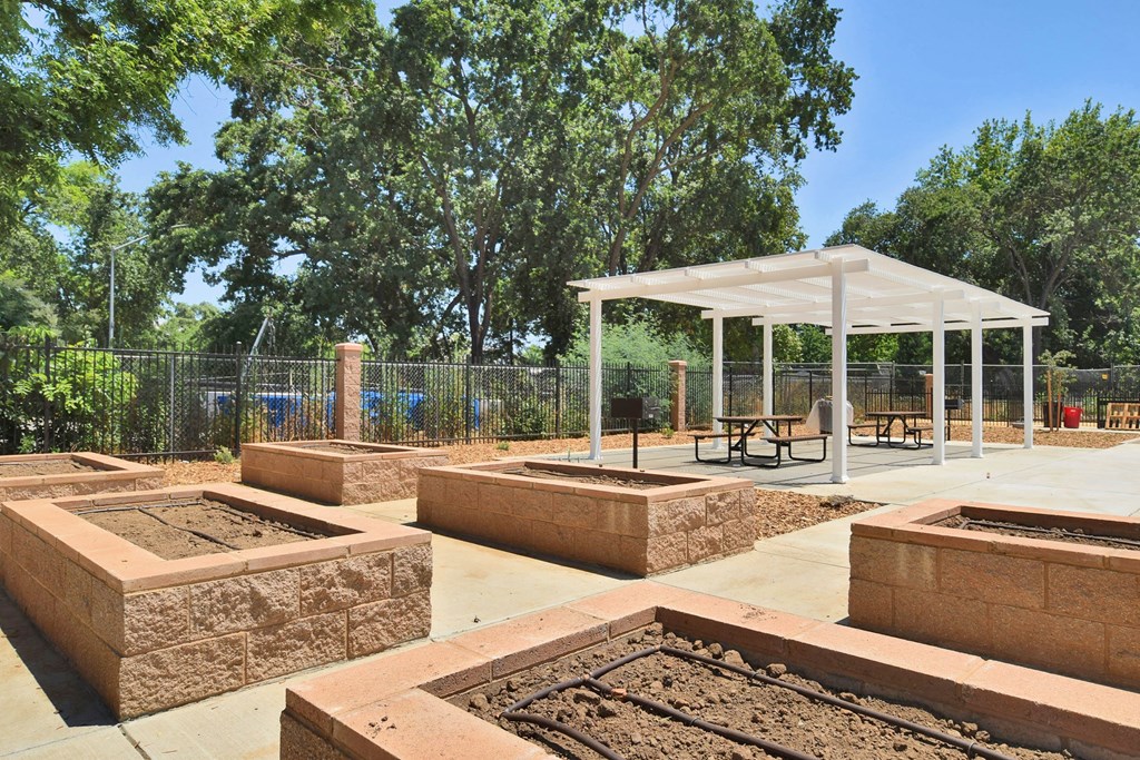 a community garden with raised beds and a pavilion