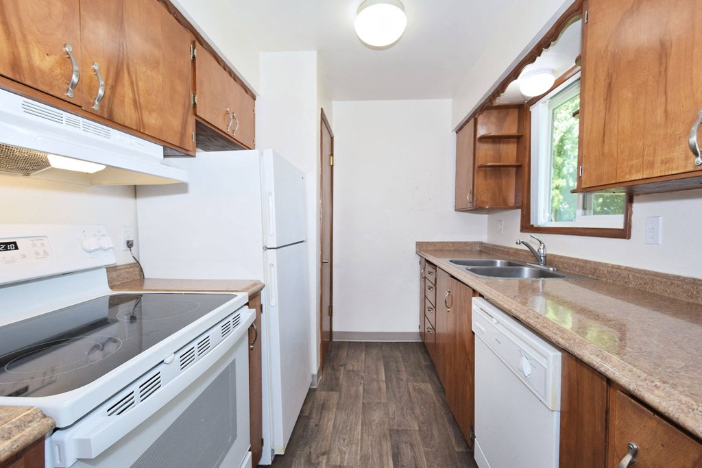 a kitchen with wooden cabinets and white appliances