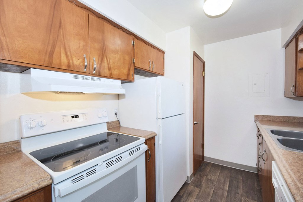 a kitchen with white appliances and wooden cabinets
