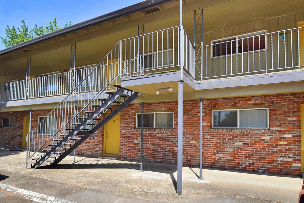 an exterior view of a building with a staircase leading to the second floor