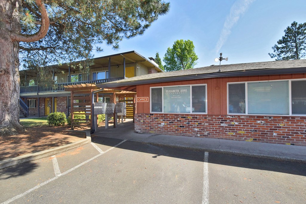 a brick building with a parking lot in front of it