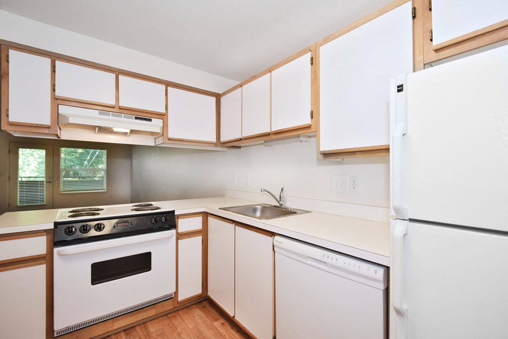 a kitchen with white cabinets and a stove and a refrigerator