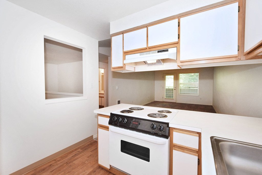 a kitchen with a stove top oven and a window