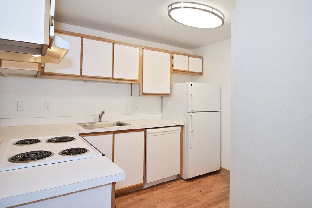 a kitchen with white appliances and white cabinets and a white refrigerator