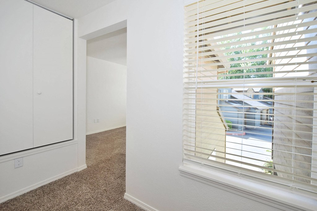 a bedroom with a large window and a white closet
