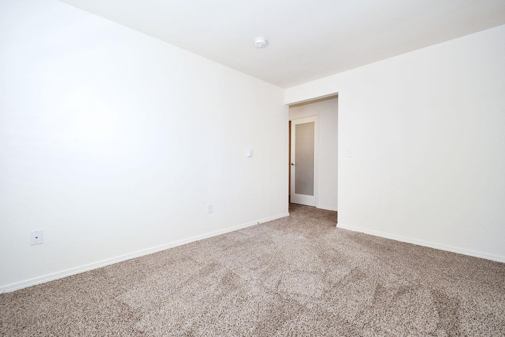 a empty room with carpet and white walls