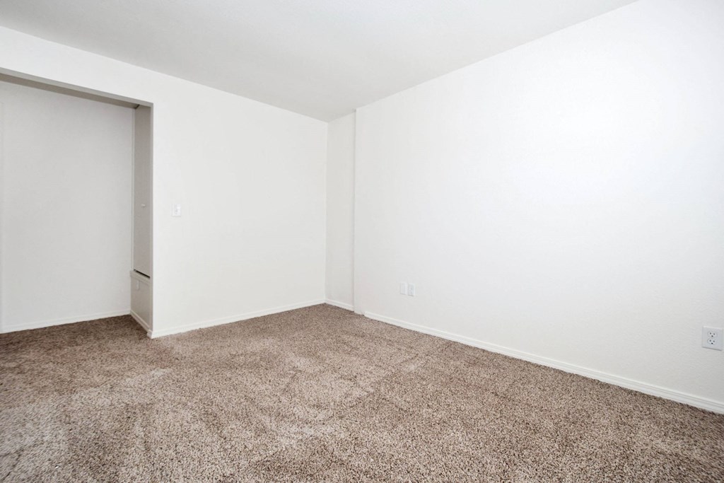 an empty room with carpet and a door