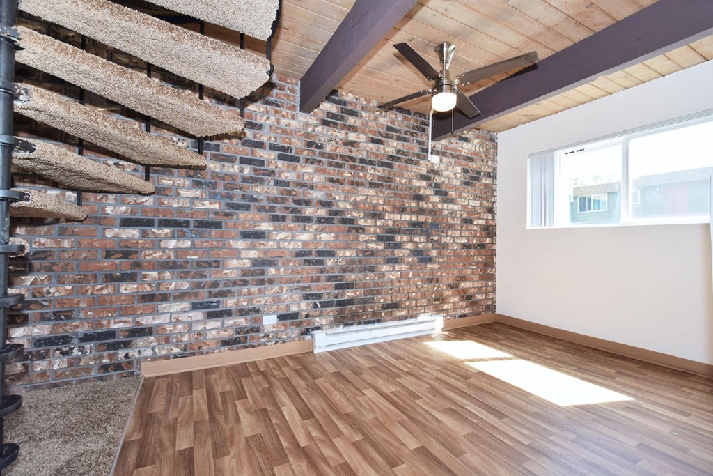 a room with hardwood floors and a brick wall