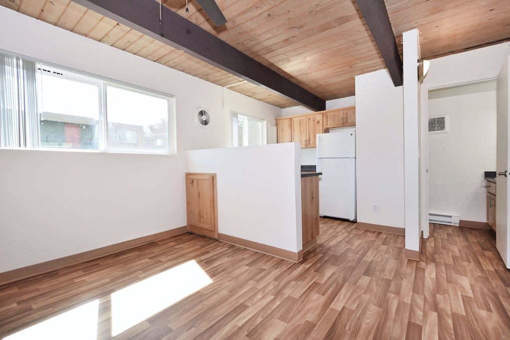 an empty room with white walls and wood floors