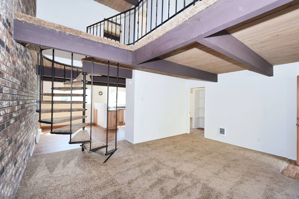 a lofted area with a staircase and carpeted flooring