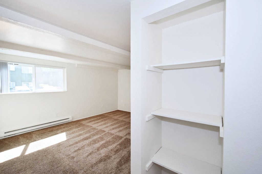 a bedroom with white walls and a window