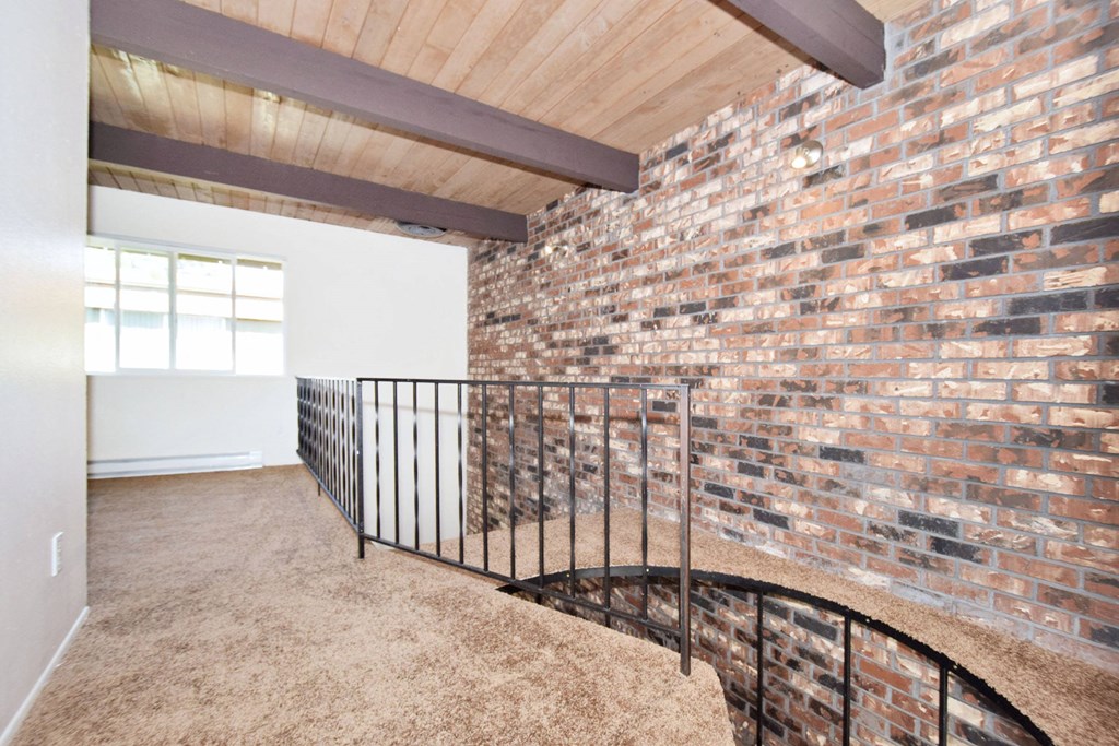 a view from the top of the stairs looking at the brick wall