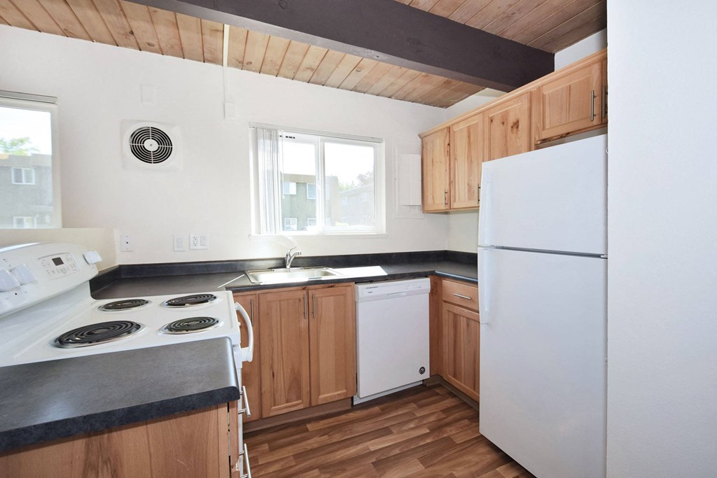 a kitchen with a white refrigerator freezer next to a stove top oven