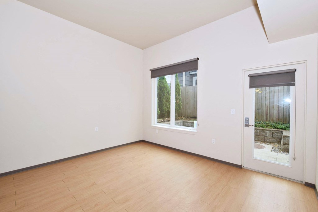 a bedroom with hardwood floors and white walls