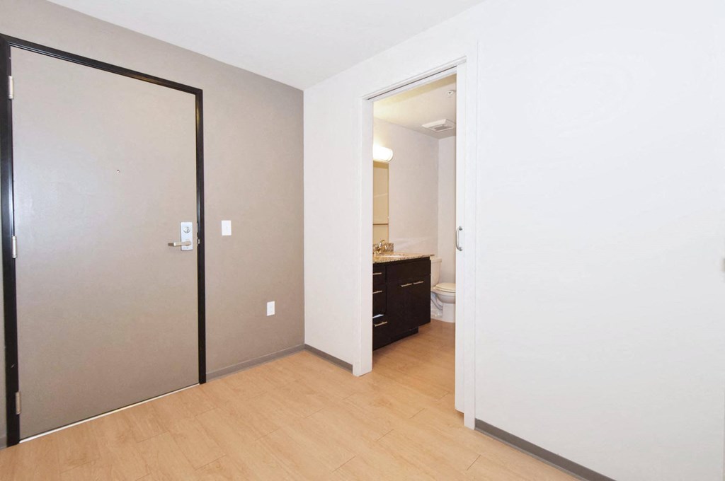 a bedroom with a medium sized bed and a doorway leading to a bathroom