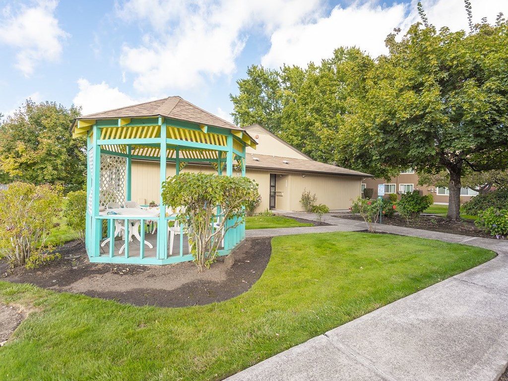 a house with a gazebo with a lawn and trees